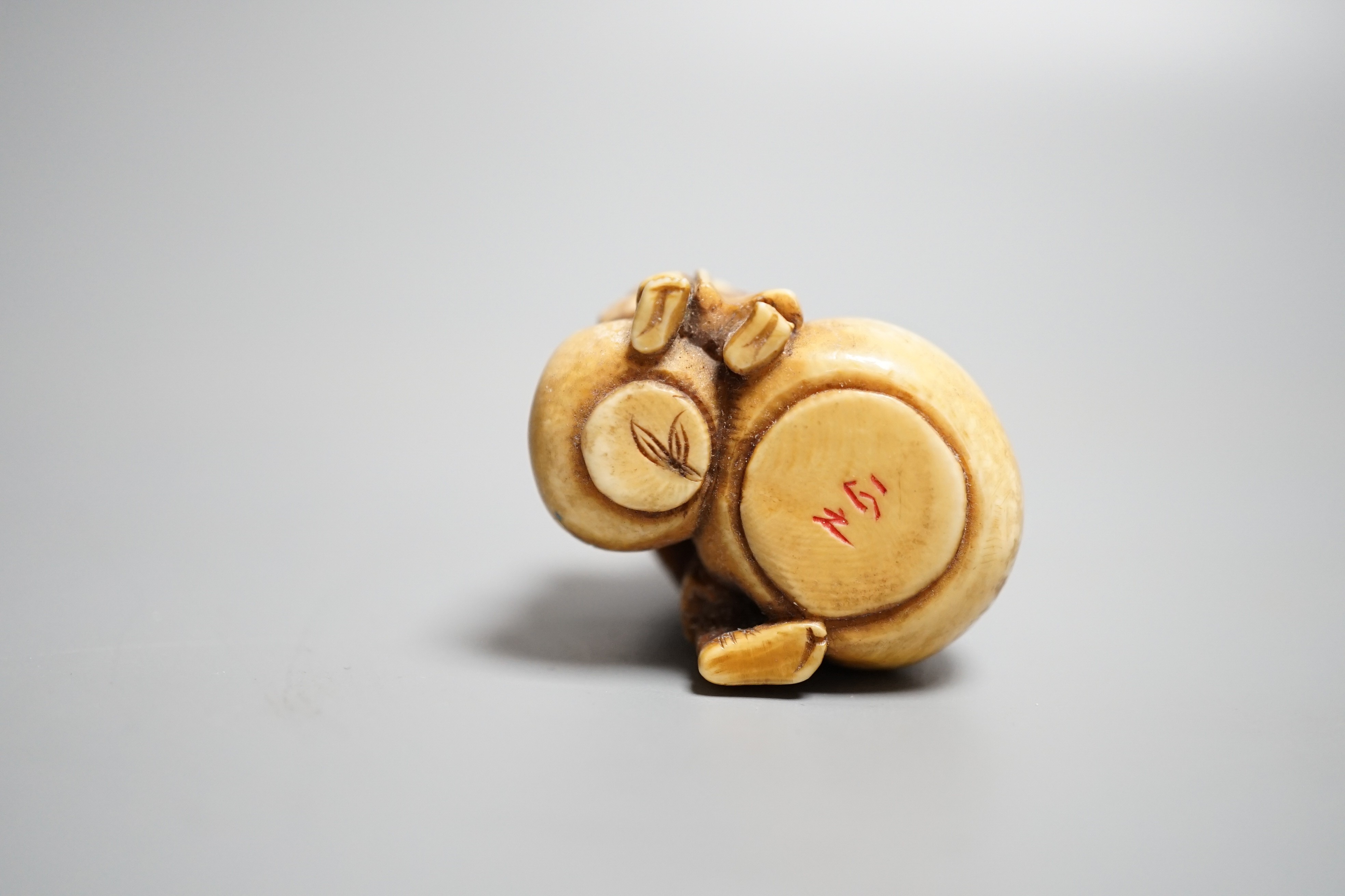 A Japanese ivory netsuke of an artisan and apprentice painting a Daruma doll, early 20th century,height 4cm